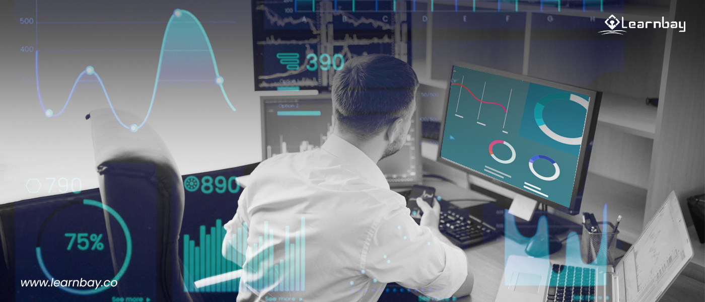 A data science professional seated in front of a desktop analyzes the 'line graphs' and 'charts.' A few overlapping figures show a pie chart, two line graphs, and a bar graph in the background.